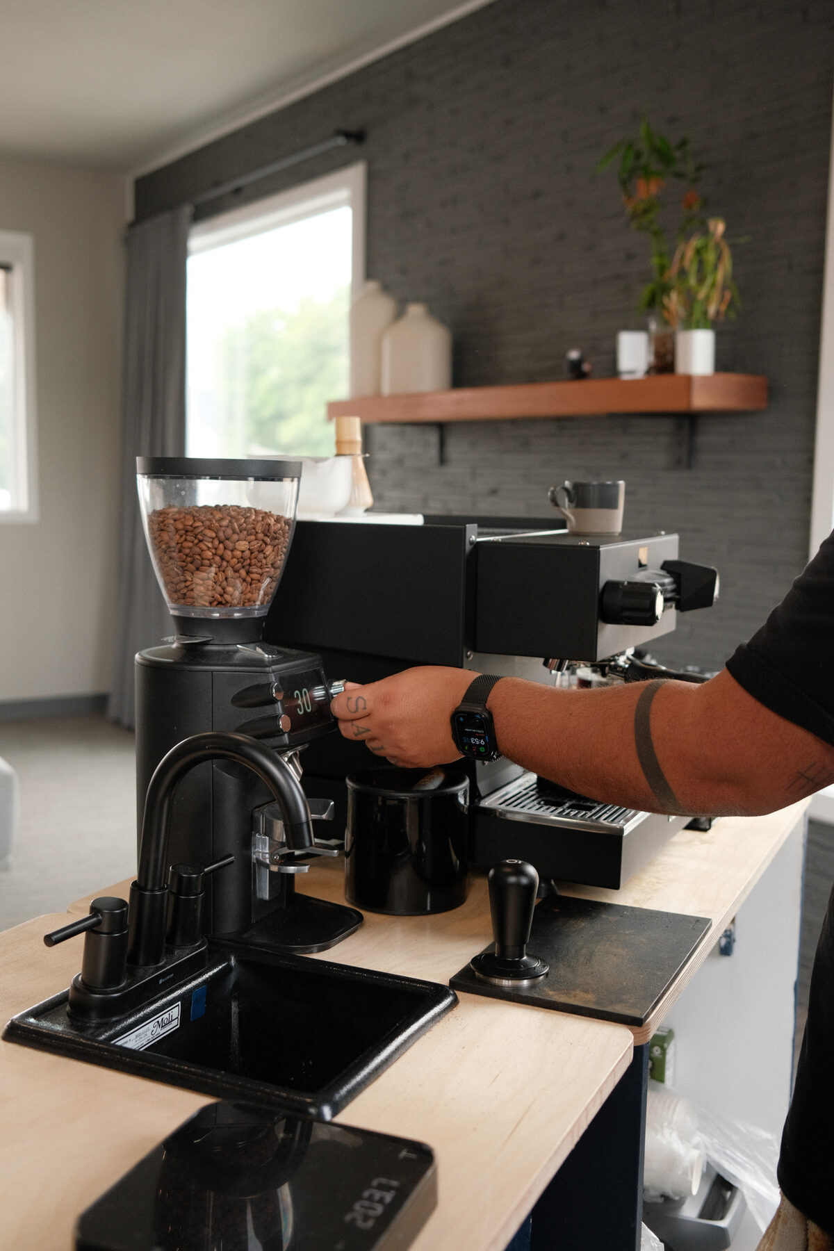 The Sigo espresso bar set up and ready to pour, La Marzocco and grinder on a wood counter