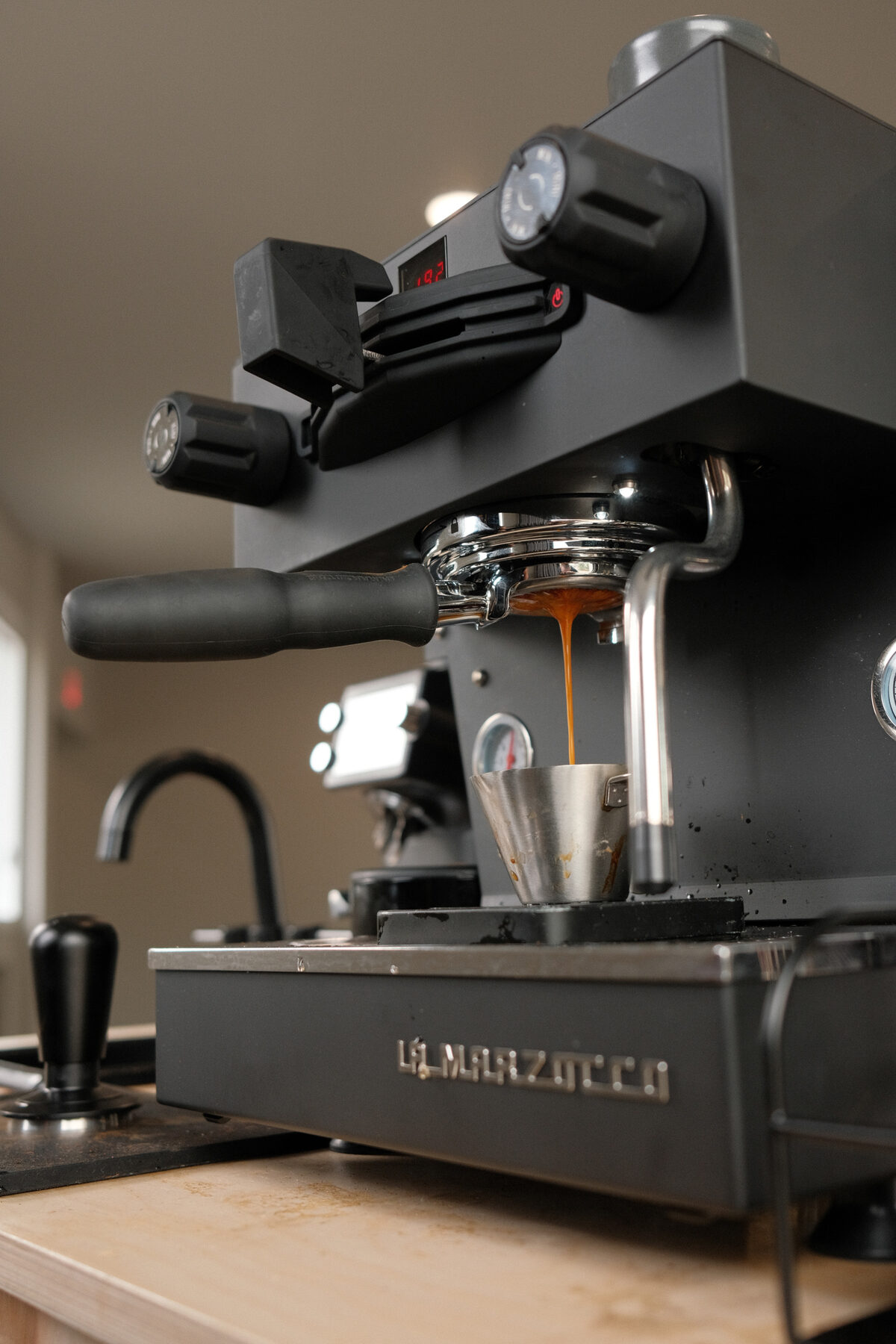 Espresso running from the La Marzocco portafilter into a pitcher